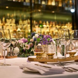 Collection dining experience, table with whisky stave and whisky, bottles in the background.