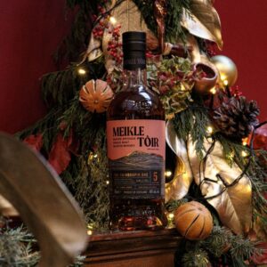 A bottle of Meikle Toir - The Chinquapin, pictured with a festive background